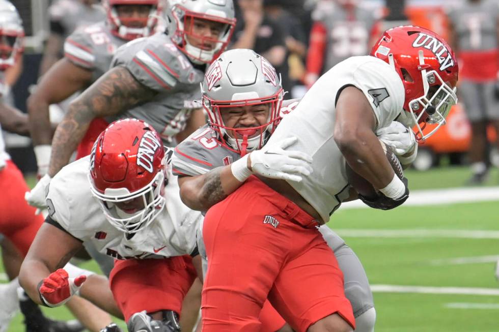 UNLV defensive back Silas Sagote tackles running back Michael Allen during UNLV football&#x2019 ...