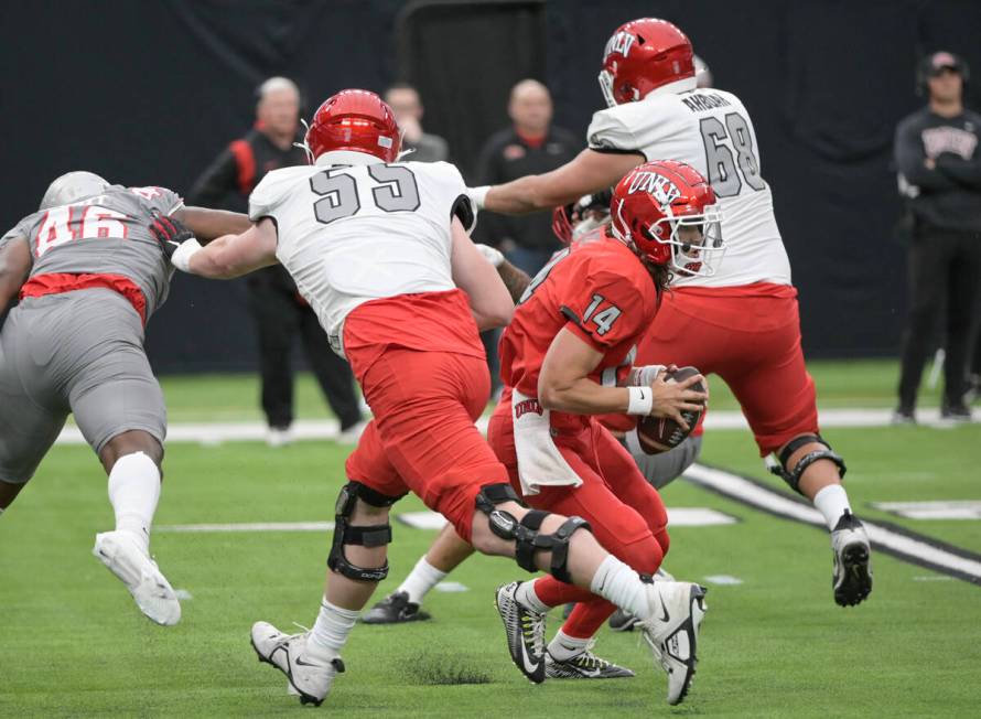 UNLV quarterback Gael Ochoa gets a block from offensive linemen Matthew Greene, left, and Jayde ...