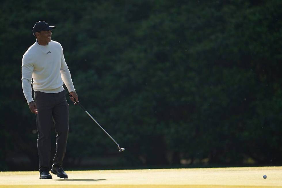 Tiger Woods smiles on the 11th green during a practice round in preparation for the Masters gol ...