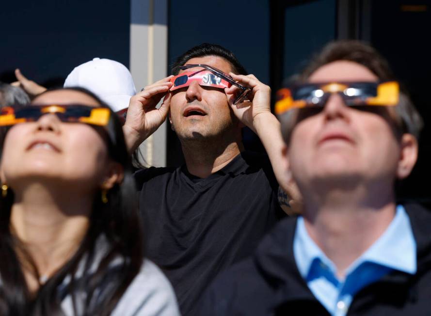 People watch a partial solar eclipse at the observation deck at The Strat, on Monday, April 8, ...