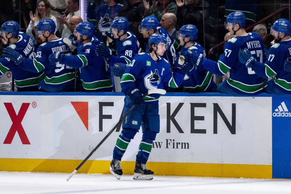 Vancouver Canucks' Quinn Hughes (43) celebrates with his teammates after his goal against the V ...