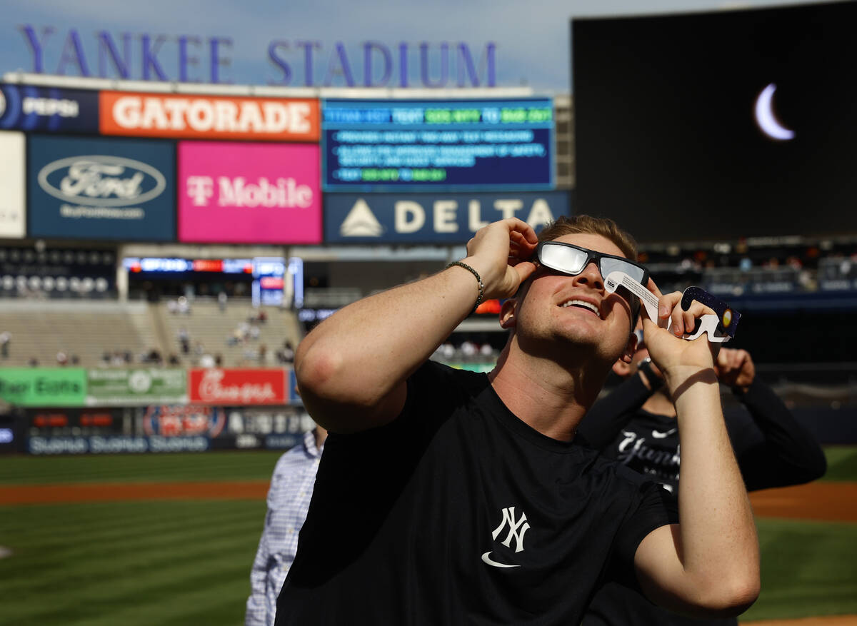 New York Yankees' Clarke Schmidt watches the eclipse from Yankee Stadium, Monday, April 8, 2024 ...