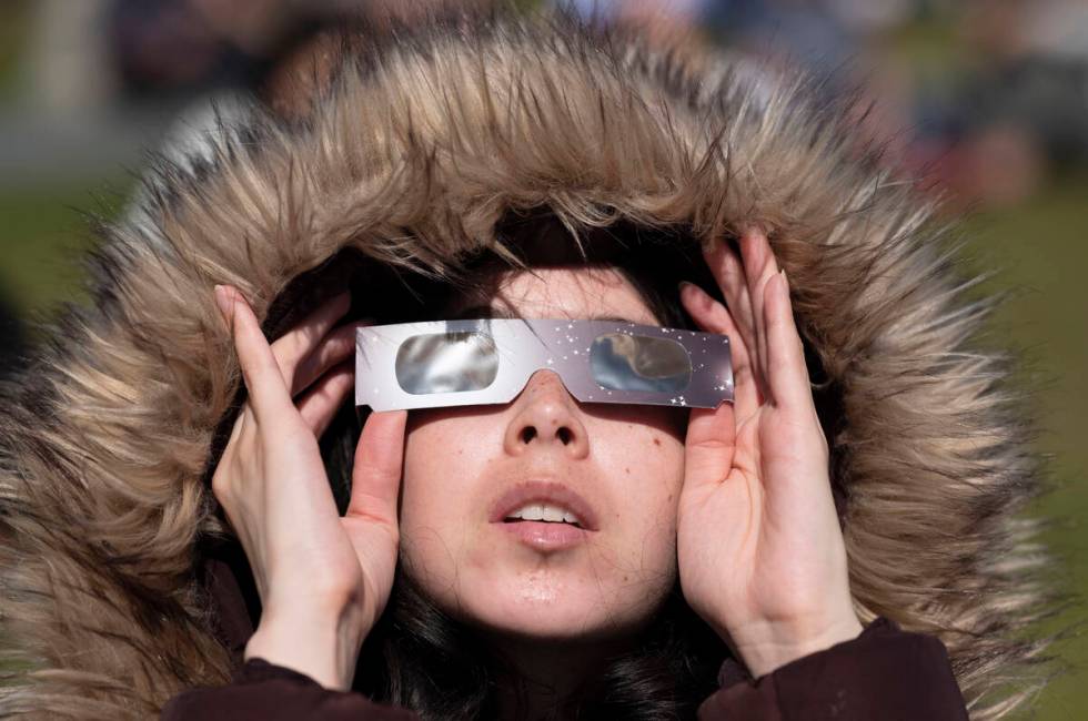 Virginia Salcido wears special glasses to watch a solar eclipse from Griffith Observatory on Mo ...