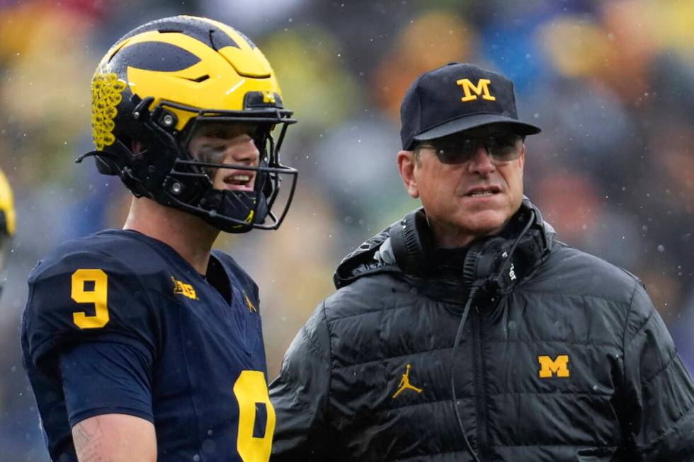 Michigan quarterback J.J. McCarthy (9) and head coach Jim Harbaugh talk in the second half of a ...