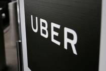 FILE - In this March 15, 2017, file photo, a sign marks a pick-up point for the Uber car servic ...