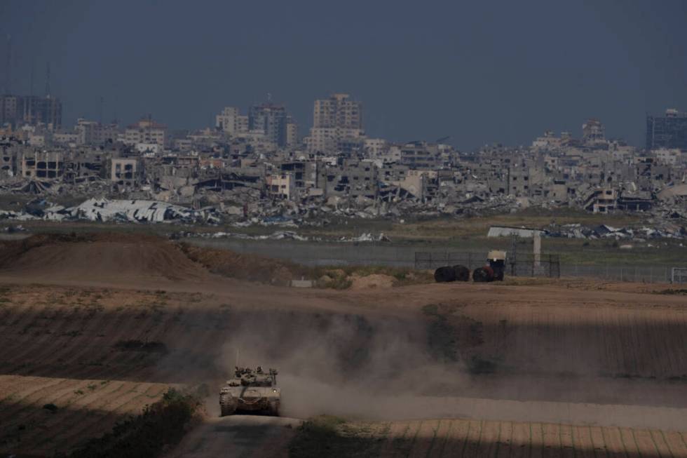 Israeli soldiers move on the top of a tank near the Israeli-Gaza border, as seen from southern ...