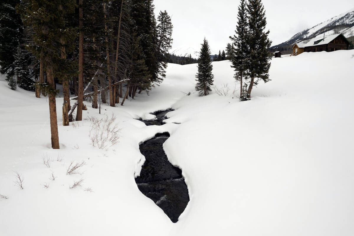 The East River flows beneath snow Thursday, March 14, 2024, in Gothic, Colo. Billy Barr's measu ...
