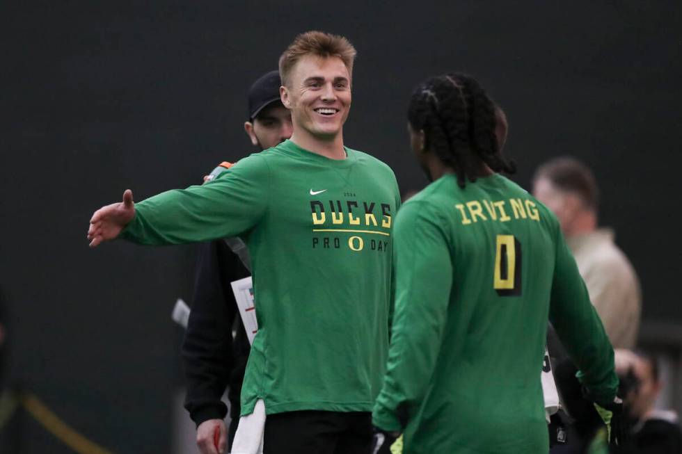 Oregon quarterback Bo Nix (10) high fives running back Bucky Irving (0) during a position drill ...