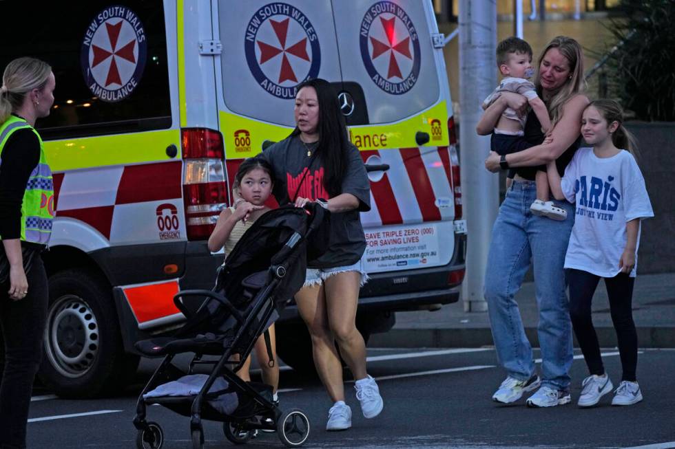 People are led out from the Westfield Shopping Centre where multiple people were stabbed in Syd ...