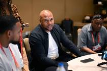 Las Vegas Raiders head coach Antonio Pierce, center, talks with reporters during an AFC coaches ...
