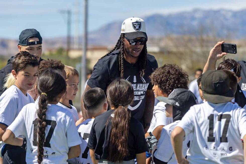 Raiders wide receiver Davante Adams, center, huddles with participants of his youth camp on Sun ...