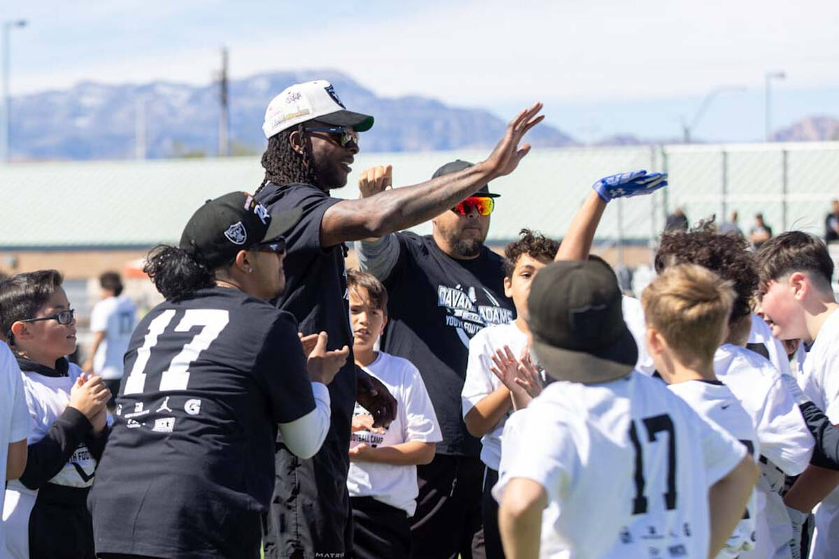 Raiders wide receiver Davante Adams high fives with participants of his youth camp on Sunday, A ...