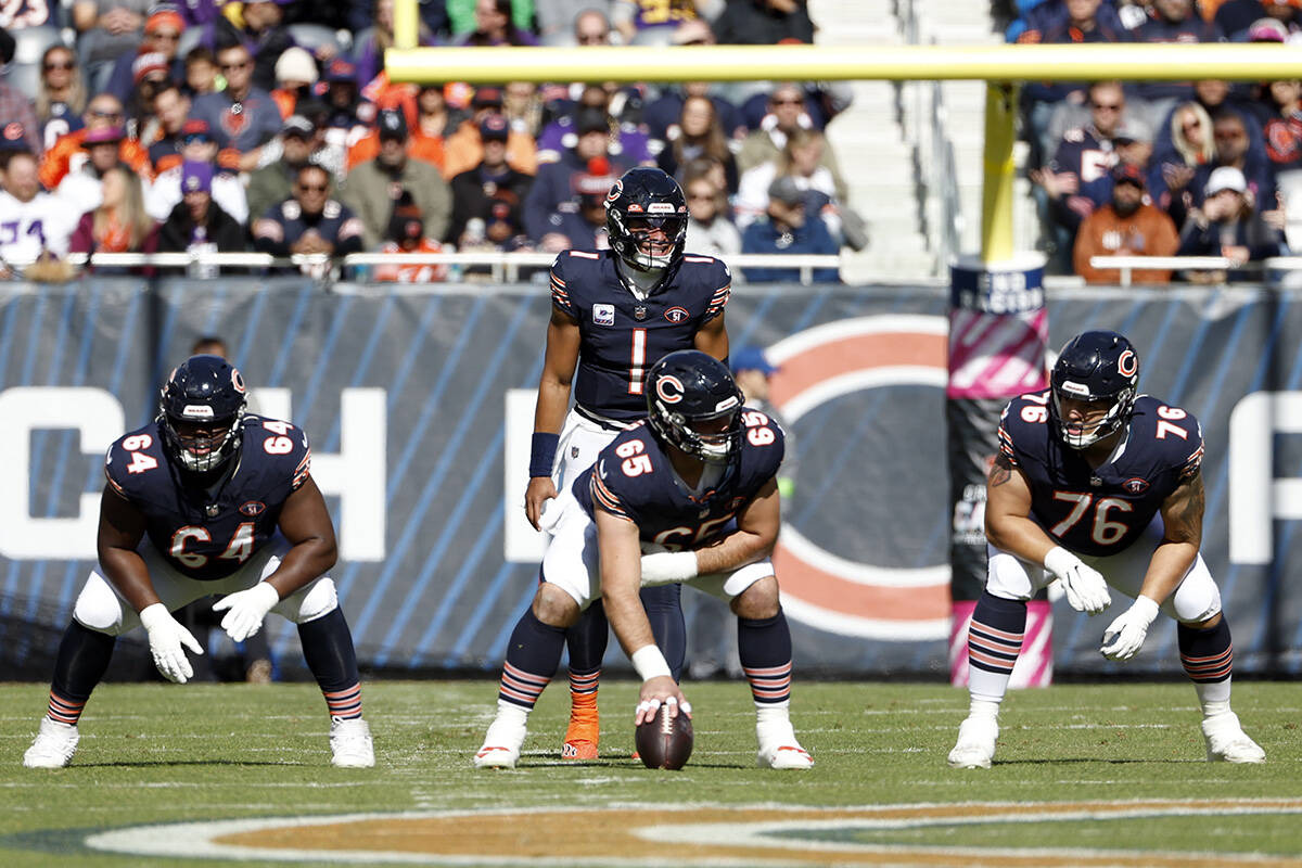 Chicago Bears quarterback Justin Fields (1) waits for the ball from center Cody Whitehair (65) ...
