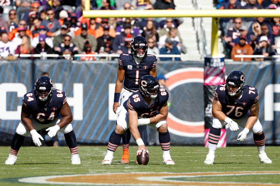 Chicago Bears quarterback Justin Fields (1) waits for the ball from center Cody Whitehair (65) ...