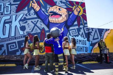 Golden Knights mascot Chance embraces mural artist Anthony Ortega as they view the Golden Knigh ...