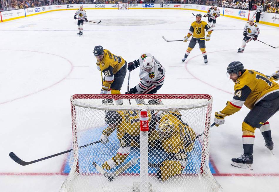 Golden Knights goaltender Logan Thompson (36) and defenseman Noah Hanifin (15) both chase a puc ...