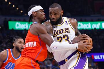 Los Angeles Lakers forward LeBron James, right, drives as Oklahoma City Thunder guard Shai Gilg ...