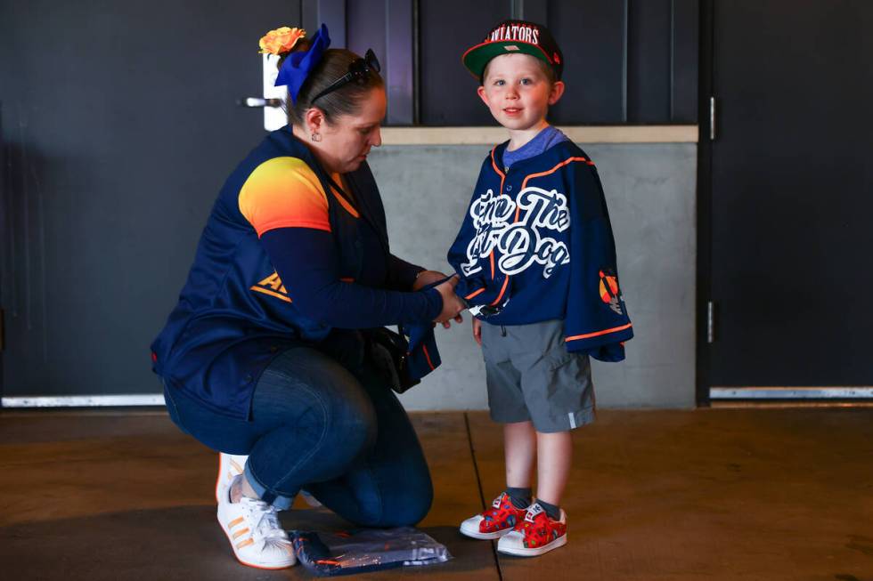 Nicole Gonzalez-Diaz ties a Finn the Bat Dog jersey on her nephew Alexander Voyles-Diaz, 5, bef ...