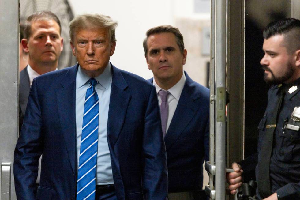 Former President Donald Trump walks through a doorway during the second day of jury selection, ...