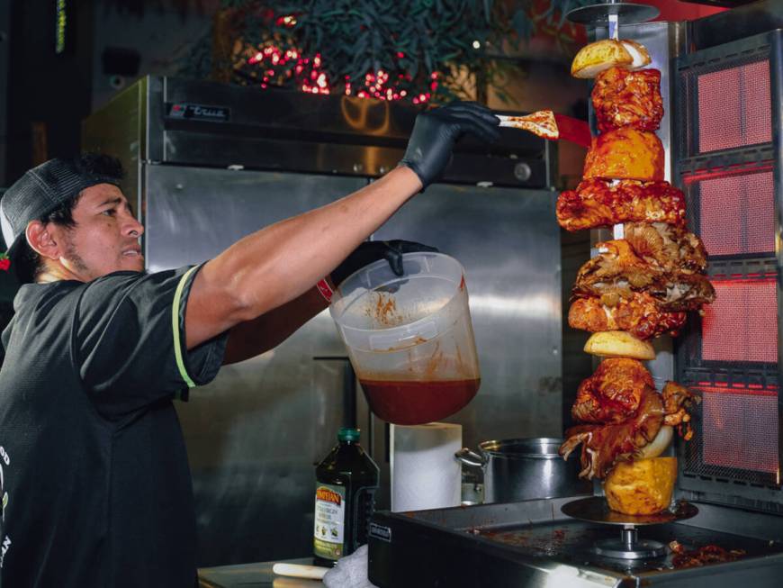 Marinating foods on the vertical spit at the 2023 Vegas Unstripped food and drink festival in d ...