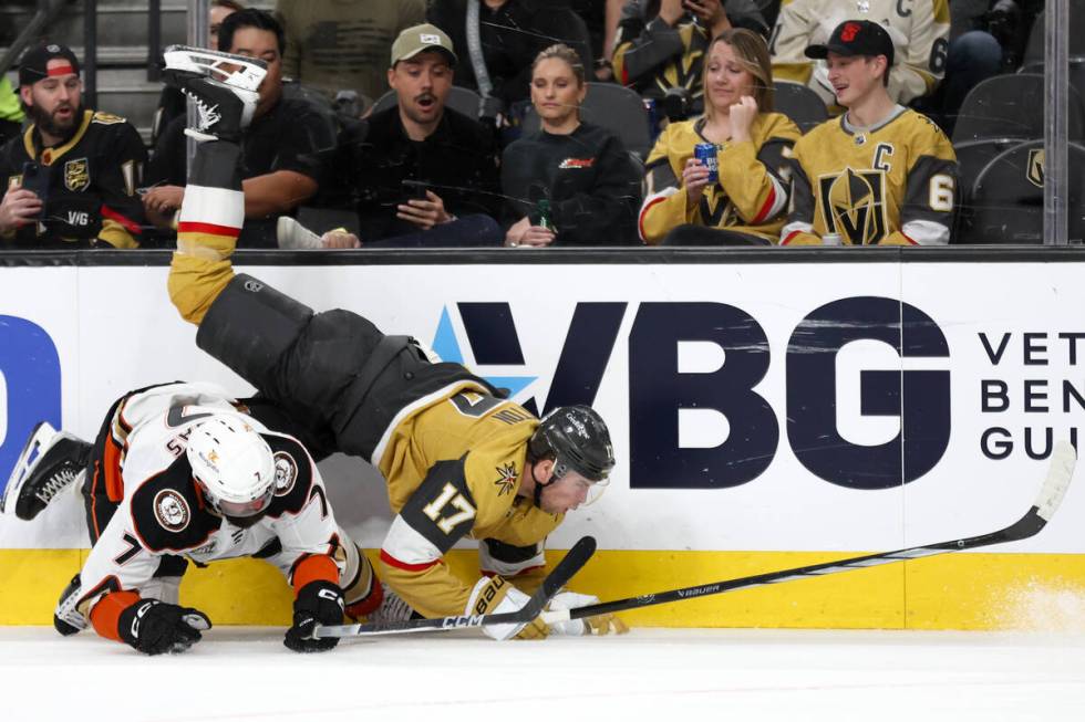 Golden Knights defenseman Ben Hutton (17) falls to the ice after colliding with Ducks defensema ...