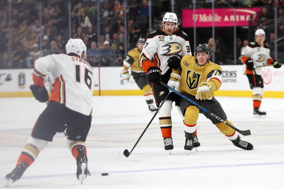 Golden Knights left wing Pavel Dorofeyev (16) struggles against Ducks defenseman William Lagess ...