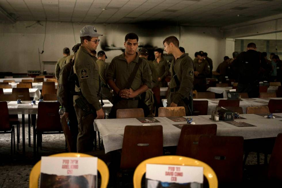 Israeli soldiers look at chairs for hostages held in Gaza at a Passover Seder table on Thursday ...