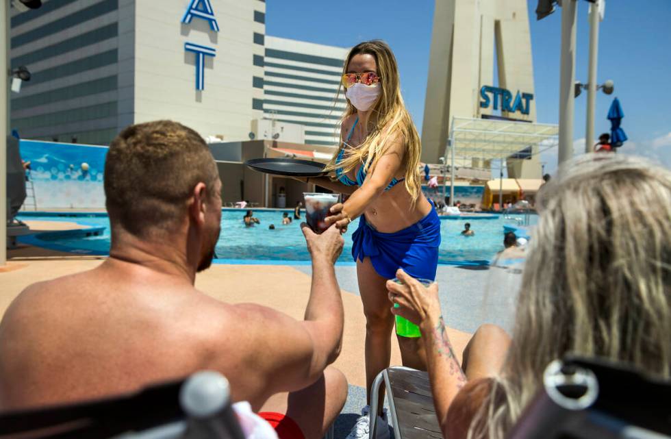 A cocktail waitress serves drinks to guests at the pool at The Strat on Saturday, June 6, 2020 ...