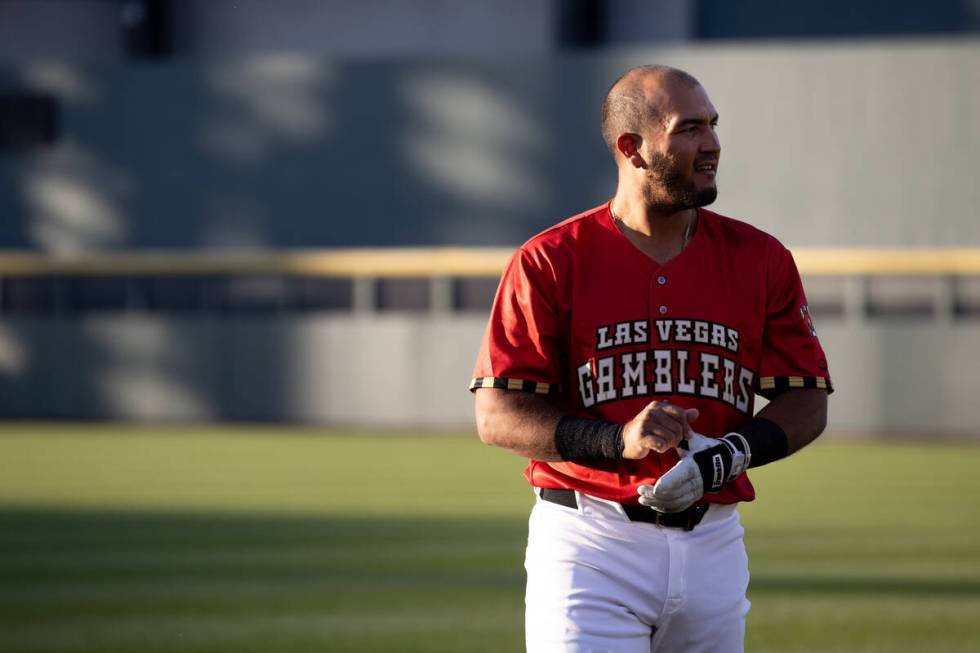 Las Vegas Aviators catcher Carlos Pérez, wearing a Las Vegas Gamblers jersey, warms up bef ...