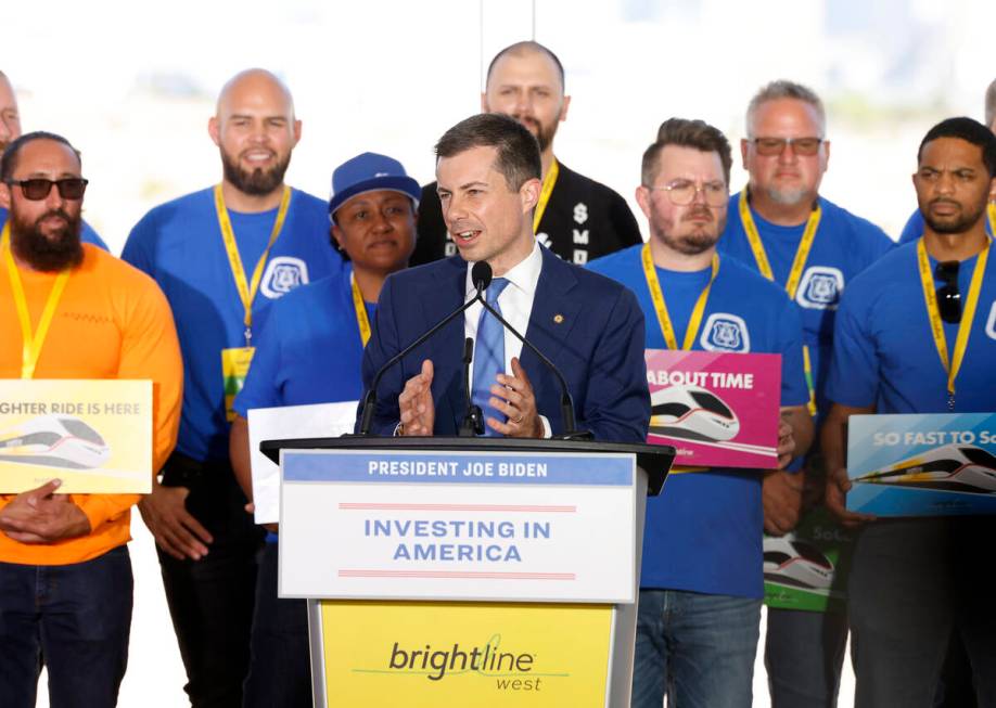 U.S. Department of Transportation Secretary Pete Buttigieg, flanked by union workers, speaks du ...