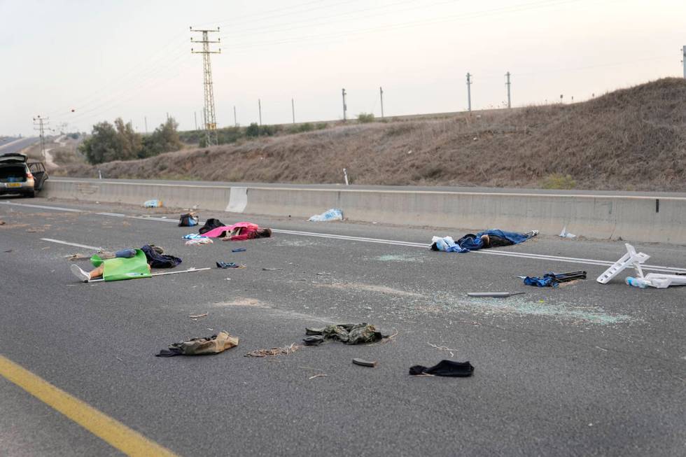 FILE - Israelis killed by Hamas militants lie on the road near Sderot, Israel, on Saturday, Oct ...