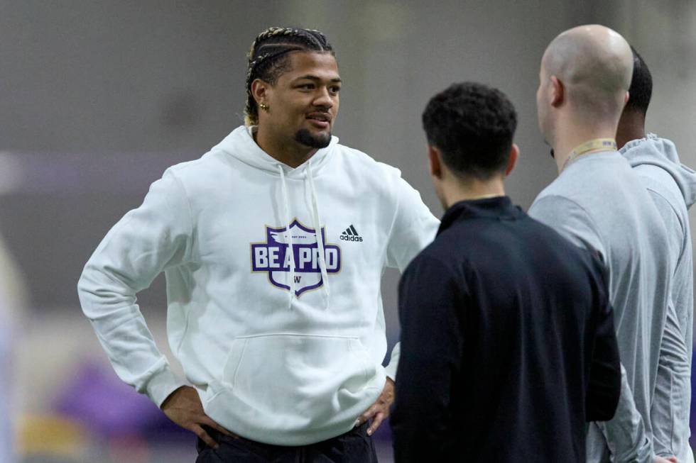 FILE - Washington wide receiver Rome Odunze talks while standing on the field during Washington ...