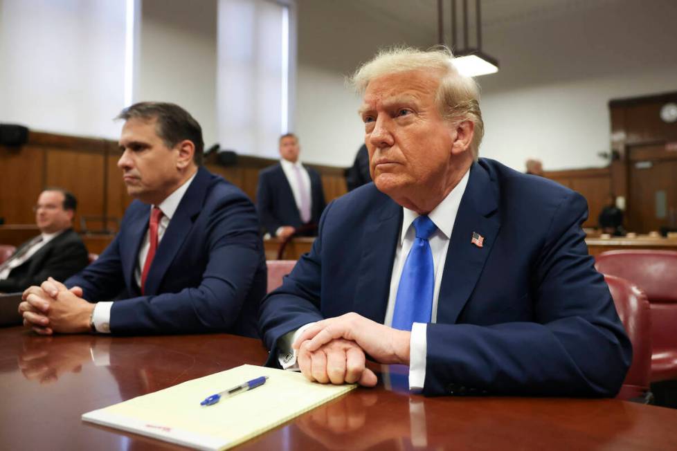 Former president Donald Trump, center, awaits the start of proceedings at Manhattan criminal co ...