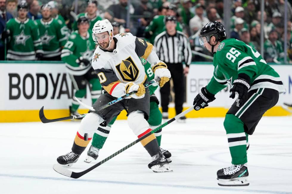 Vegas Golden Knights center Nicolas Roy (10) flips the puck forward over the stick of Dallas St ...