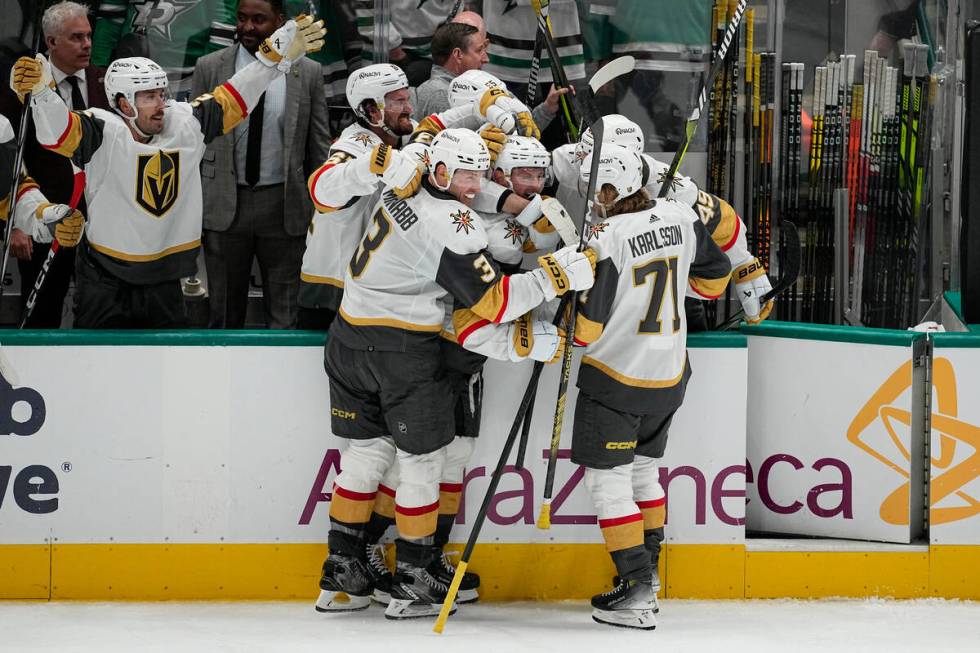 Vegas Golden Knights players celebrate an empty net goal by Jack Eichel, center, during the thi ...
