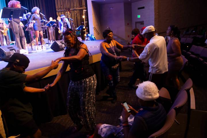 Attendees dance as Vegas Groove & The Silver State Horns perform during an event celebratin ...