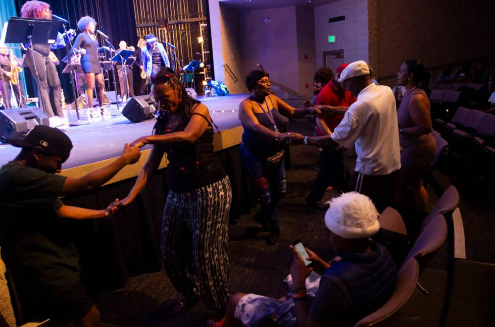Attendees dance as Vegas Groove & The Silver State Horns perform during an event celebratin ...