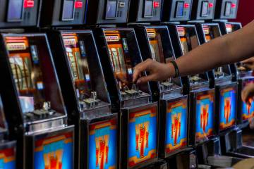 A player inserts a coin into a machine within the revamped slots area called Slots A Fun which ...