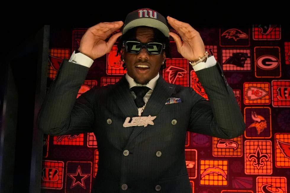 LSU wide receiver Malik Nabers puts on a hat after being chosen by the New York Giants with the ...