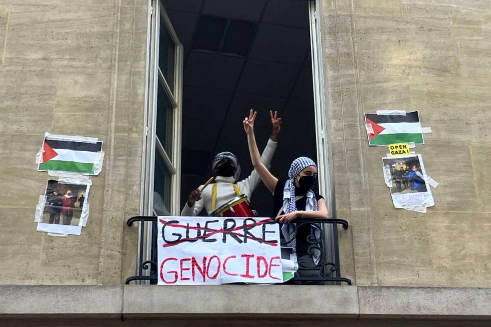 Students blocking the Sciences Po university flash the V sign Friday, April 26, 2024 in Paris. ...