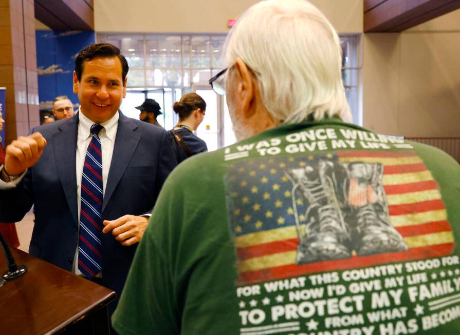 Nevada Secretary of State Francisco Aguilar, left, chats with Phillip Davis, a veteran of the U ...