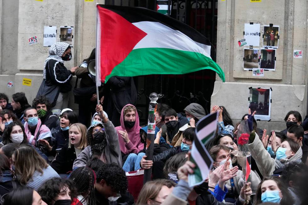 A student wave a palestinian flag outside Sciences-Po university in Paris Friday, April 26, 202 ...