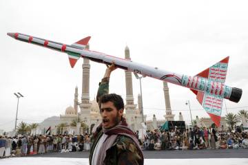 A Houthi supporter raises a mock rocket during a rally against the U.S. and Israel and to suppo ...