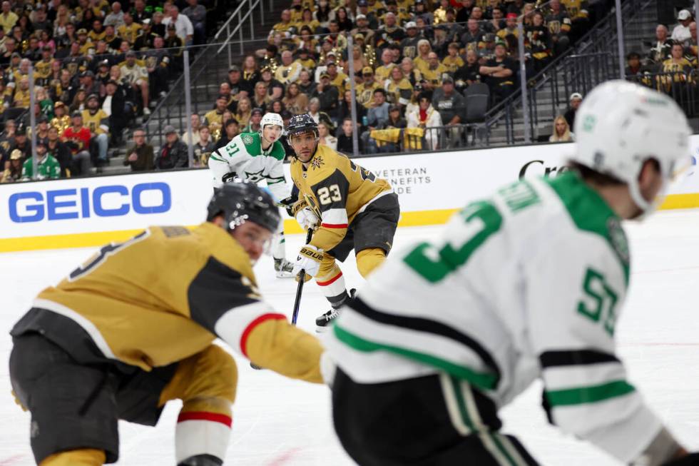 Golden Knights defenseman Alec Martinez (23) and Stars left wing Jason Robertson (21) eye the a ...