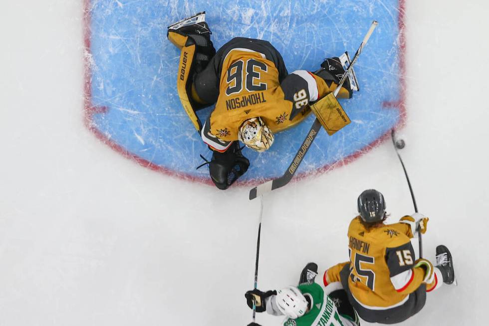 Golden Knights defenseman Noah Hanifin (15) maneuvers the puck away from Knights goaltender Log ...