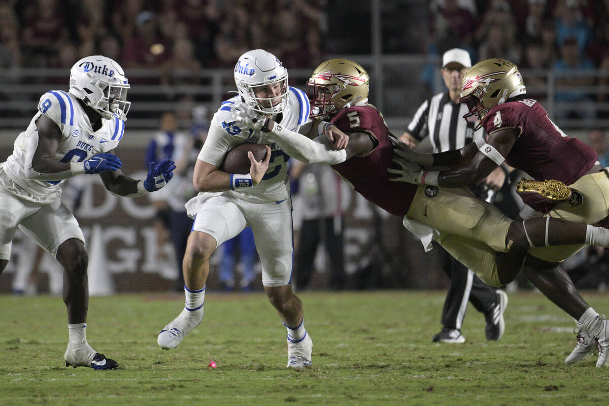 Duke quarterback Riley Leonard (13) is tackled by Florida State defensive lineman Jared Verse ( ...