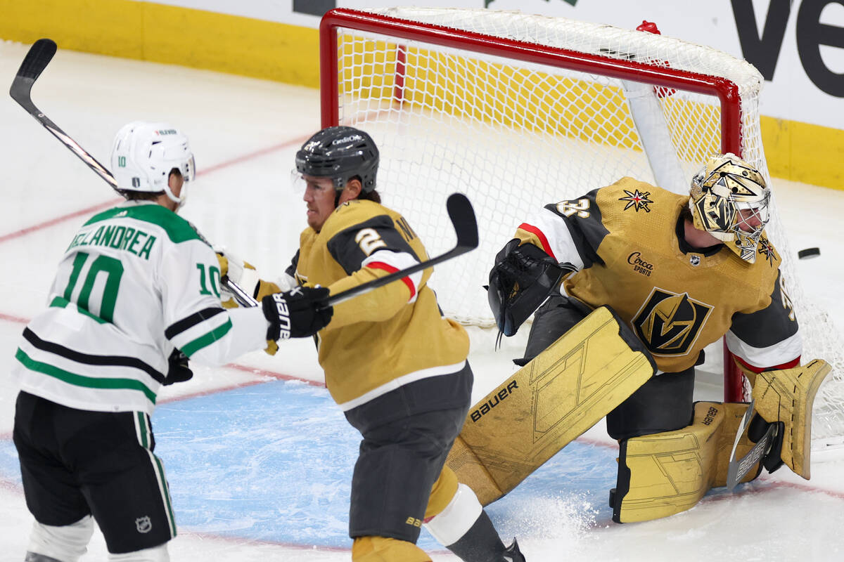 Golden Knights goaltender Logan Thompson (36) saves the puck while Knights defenseman Zach Whit ...