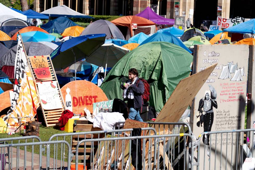 A man passes in front of the pro-Palestinian protesters' tents as they continued to occupy the ...