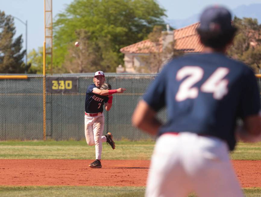 Liberty’s Konner Brown (7) throws to Shawn Mack (24) at first base during a baseball gam ...