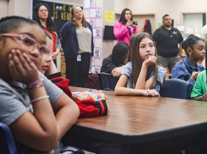 Students and media listen to a speaker at a press conference announcing a new teacher recruitme ...